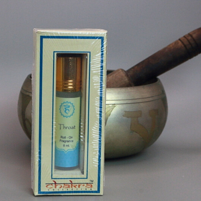 Throat chakra roll on perfume oil sitting in front of a singing bowl