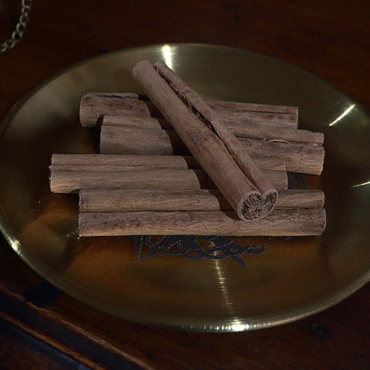 cinnamon sticks on gold plate with wooden background