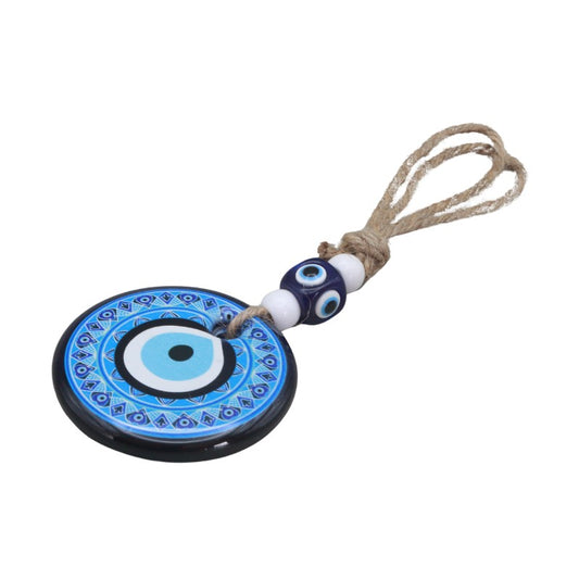 Evil eye charm with blue and white design on a white background