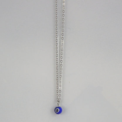 silver necklace with a blue, white and black eye shaped bead n a white background