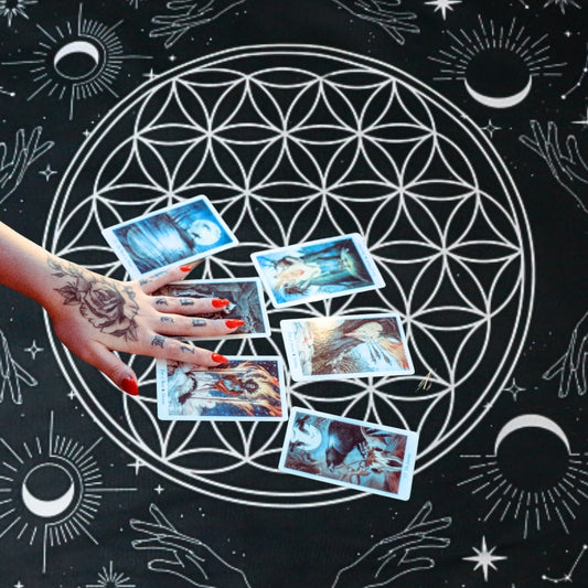 a lady performing a tarot reading on a Black & White Flower Of Life  Tarot Cloth