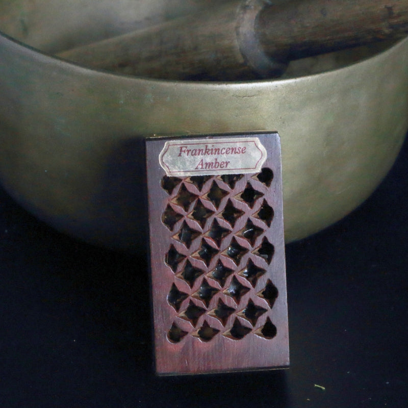 rosewood frankincense and amber rock perfume box, standing in front of a brass singing bowl