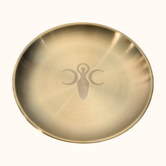 gold plate with an etched goddess symbol and 2 crescent moons  either side
