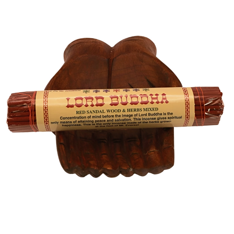 pk of hand rolled "lord buddha" tibetan incense sitting on a statue of carved wooden hands