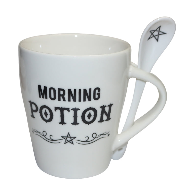 White ceramic coffee mug with the phrase "morning potion" written in black above a pentagram. A white spoon through the mug handle with a black pentagram drawn in the bowl of the spoon