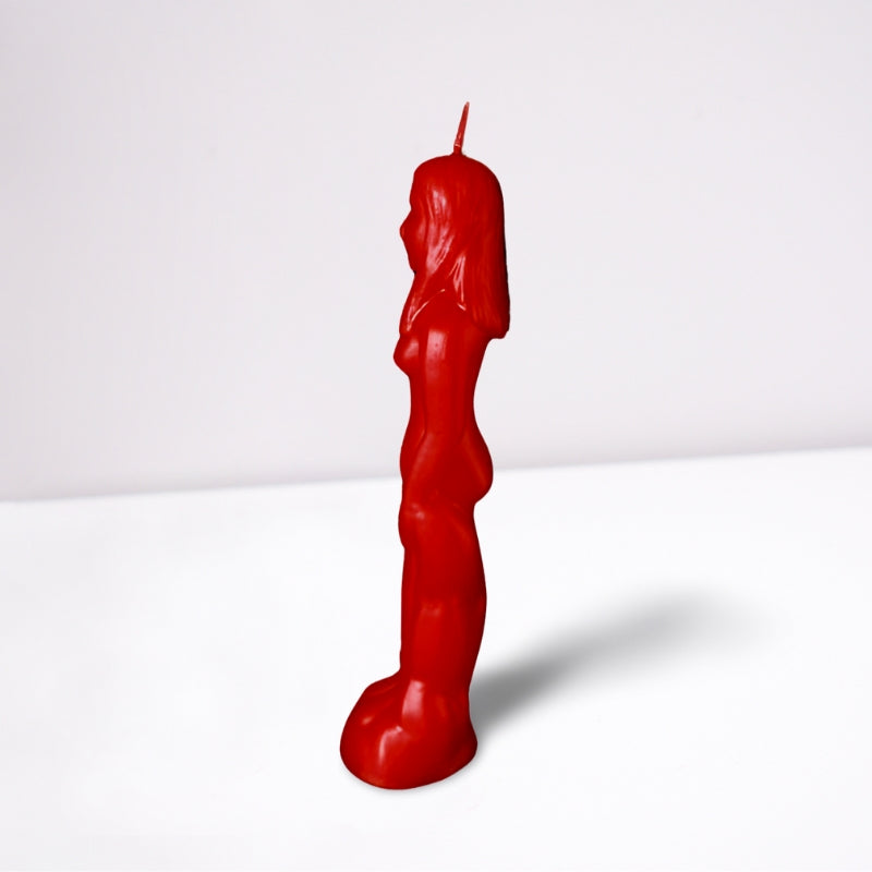 red naked figure candle in the shape of a naked female- side on- on a white background