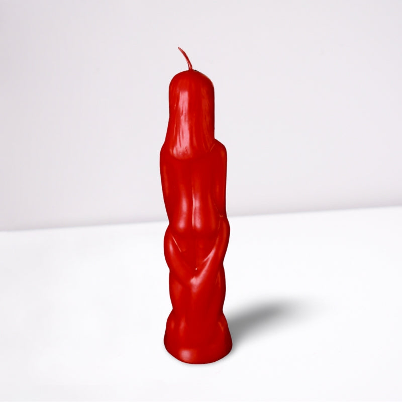 red naked figure candle in the shape of a naked female- back view- on a white background