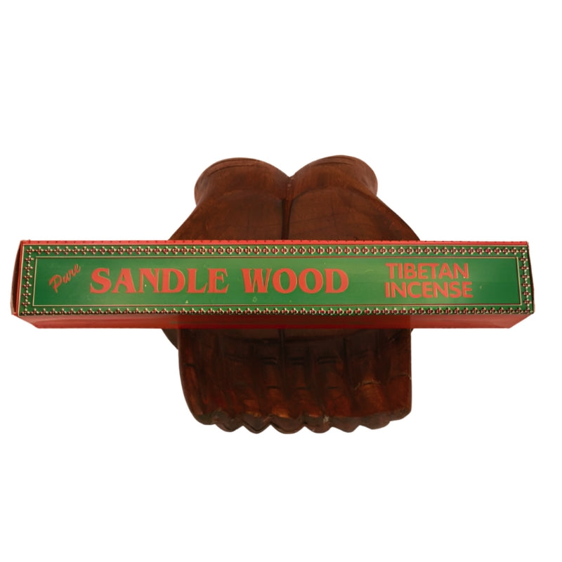 pk of hand rolled "Sandle Wood" tibetan incense sitting on a statue of carved wooden hands