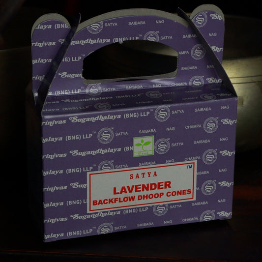 purple box of satya backflow incense cones in front of a brass singing bowl
