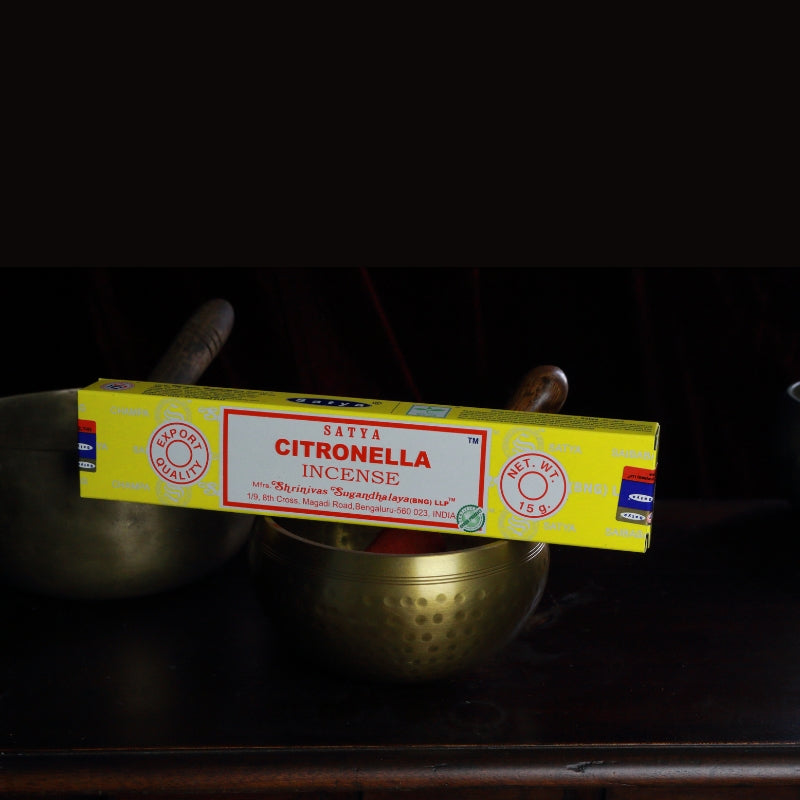 satya incense sticks sitting on a brass singing bowl