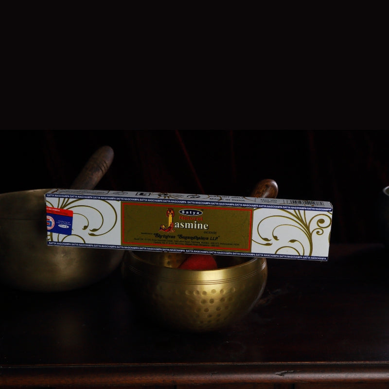 satya incense sticks sitting on a brass singing bowl