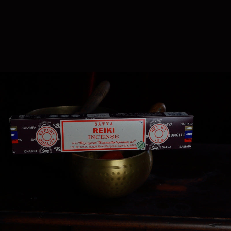 satya incense sticks sitting on a brass singing bowl