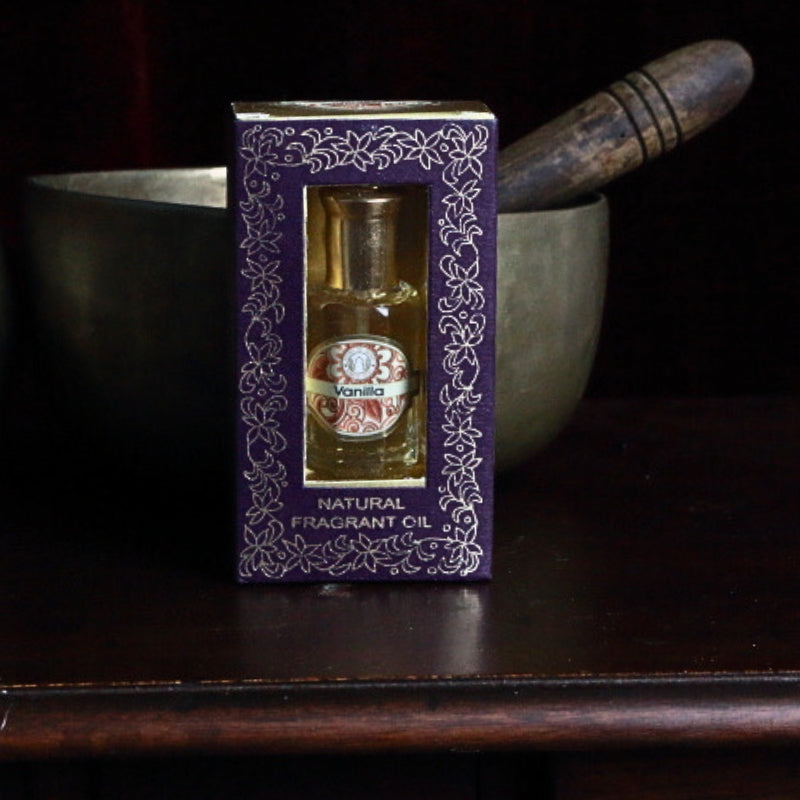 song of india vanilla perfume oil in front of a brass singing bowl on top of an apothecary cabinet