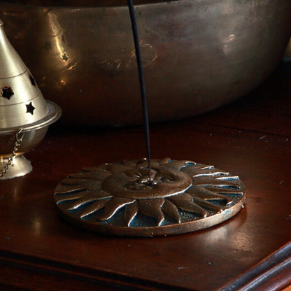 incense stick in sun and moon incense burner on a wooden table