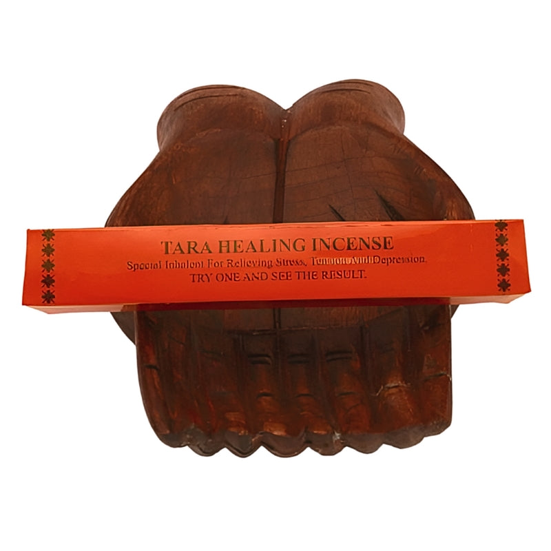 pk of "Tara healing incense" tibetan incense sitting on a statue of carved wooden hands