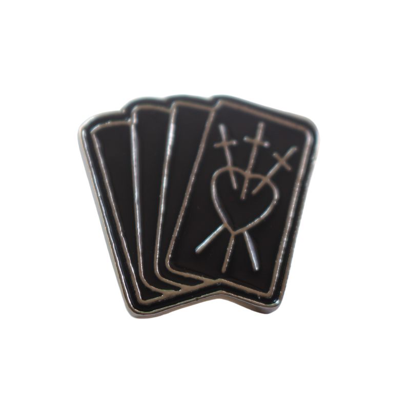enamel badge representing 4 tarot cards with the 3 of swords on the front