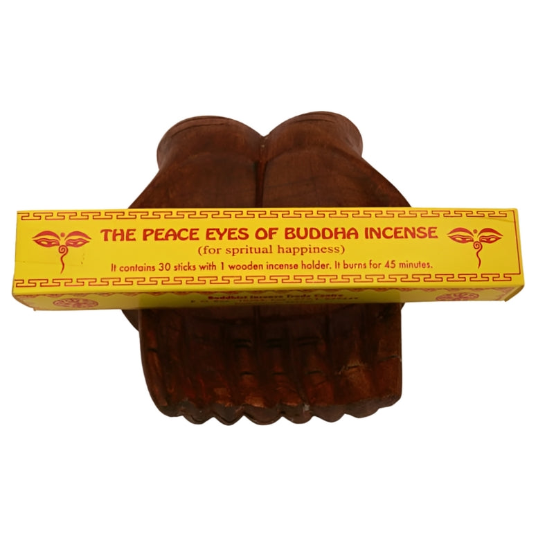 pk of hand "peace eyes of buddha " tibetan incense sitting on a statue of carved wooden hands