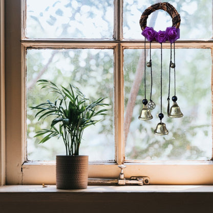 set of witches bells hanging in a window