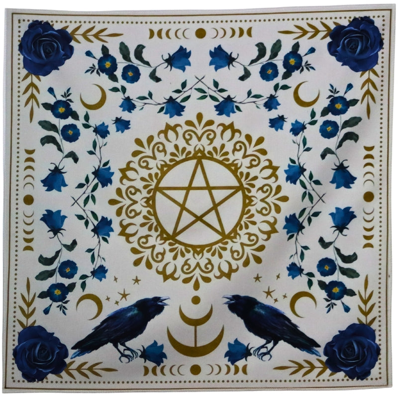 Tarot cloth. White with blue flowers surrounding a gold pentacle (5 pointed star surrounded by a circle). 2 ravens at the base of the pentacle. 