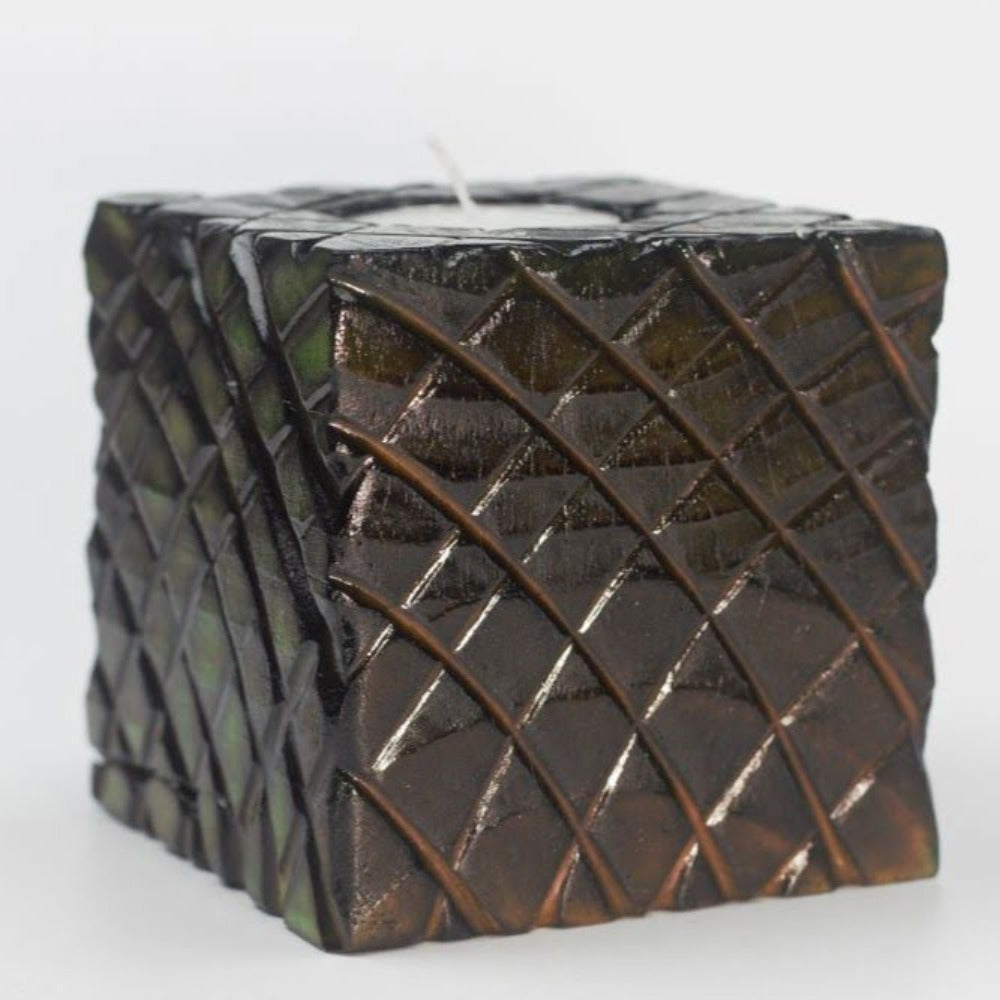 green and yellow side of multicoloured  wooden square candle holder with diagonal lines etched to resemble dragon scales. Containing a white tea light candle, on a white background