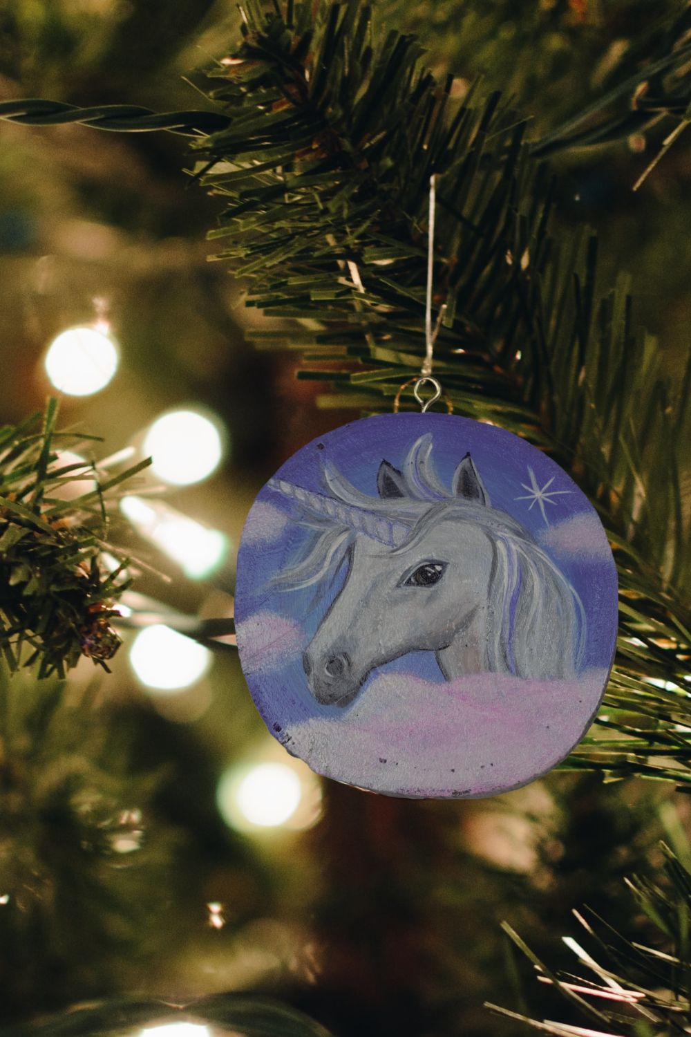 handpainted unicorn wood round ornament with lights and Christmas tree branch