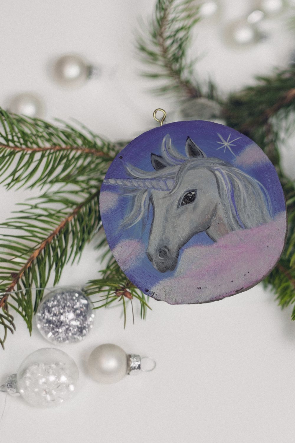 handpainted unicorn wood round ornament with baubles and Christmas tree branch