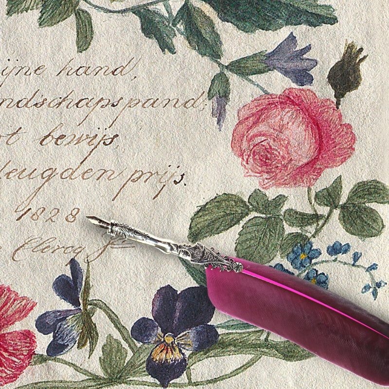 Pink feather dip pen with silver handle on top of floral lettering
