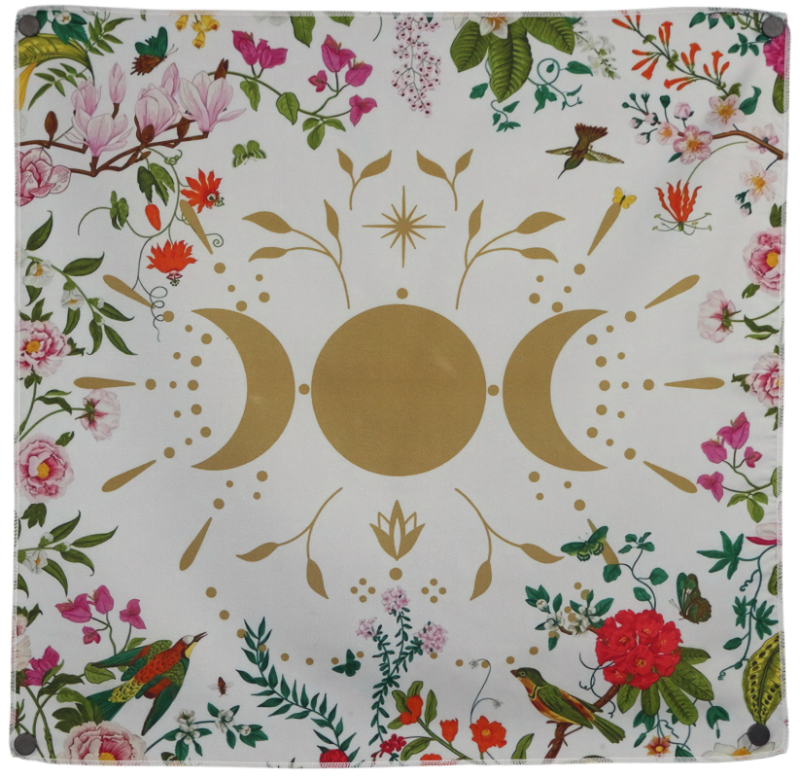 white tarot cloth with floral borders embellished with a gold moon in between two gold crescent moons