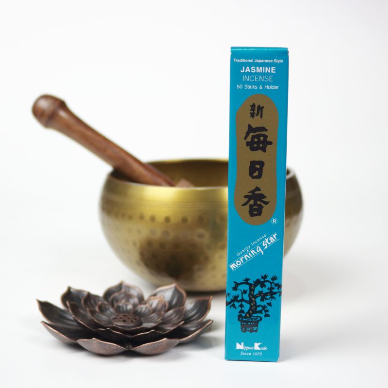 blue and gold box of jasmine scented morning star incense next to a lotus incense holder, in front of a brass singing bowl