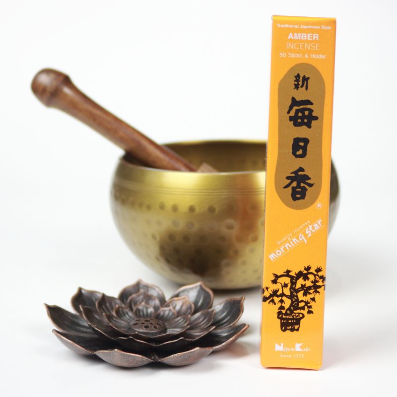 rectangle box of japanese morning star "amber" incense sticks next to a lotus incense holder and brass singing bowl