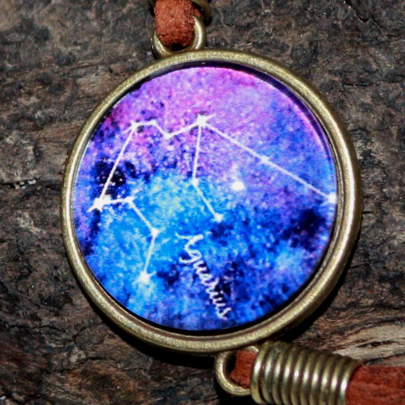  glass cabochon  featuring an image of the aquarius constellation line drawing on a blue and purple background on a piece of drift wood