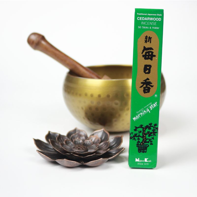 rectangle box of japanese morning star "cedarwood" incense sticks next to a lotus incense holder and brass singing bowl