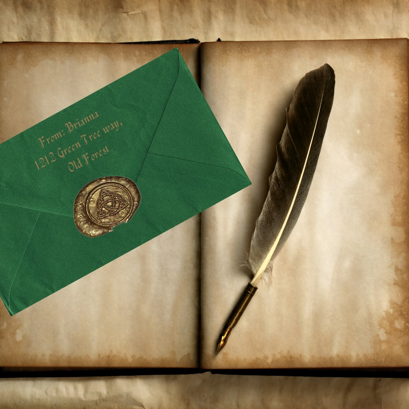 gold triquetra wax seal on a green envelope, next to a feather dip pen , sitting atop a blank, vintage notebook