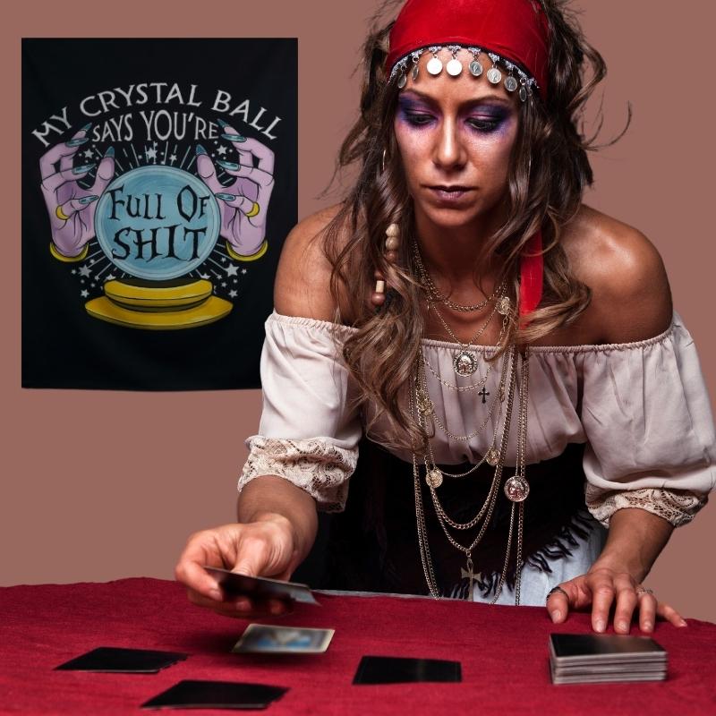 tarot reader in front of a wall hanging that reads  " my crystal ball says you're full of shit"