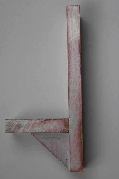 side view of red and white wooden wall mounted candle or ornament shelf 