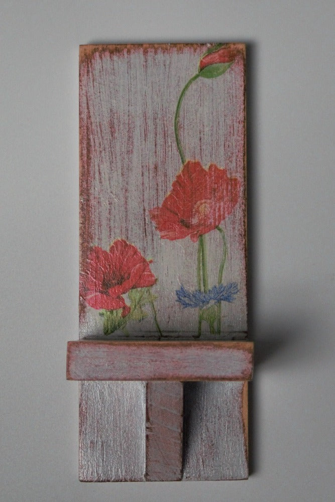 red and white wooden wall mounted candle or ornament  shelf decorated with red and blue flowers 