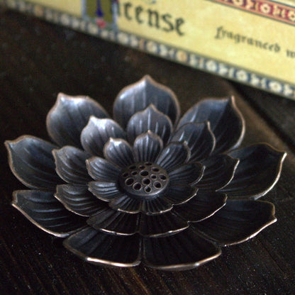 lotus flower incense holder, sitting on wood table in front of meditation incense