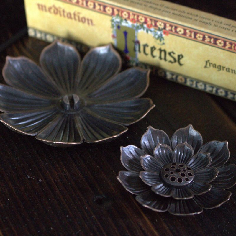 lotus flower incense holder in 2 pieces, sitting on wooden table with meditation incense in background