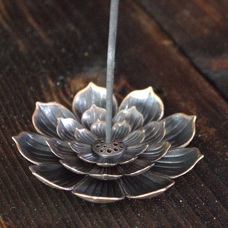 lotus flower incense holder with incense stick, sitting on wooden background