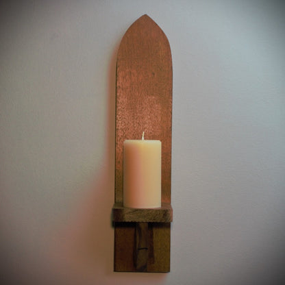 meditation candle 40 hour burn time, sitting on a wood merbau wall sconce, on a grey background