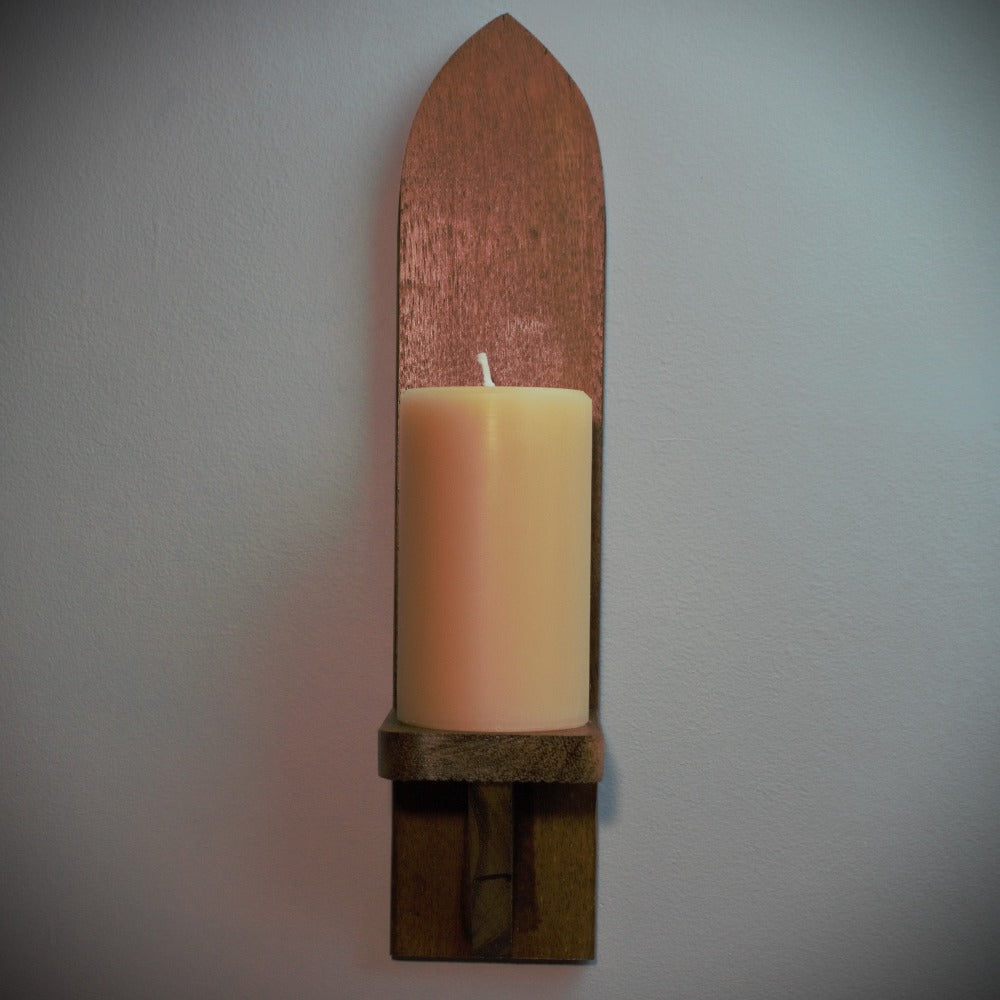 meditation candle 80 hour burn time sitting on a dark wood merbau wall sconce, on a grey background