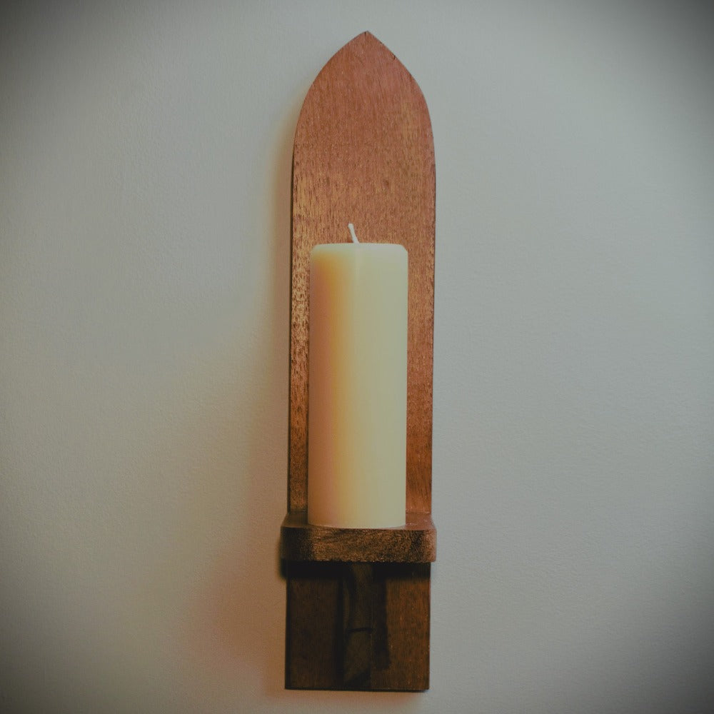 meditation candle on tall wooden wall sconce with grey background