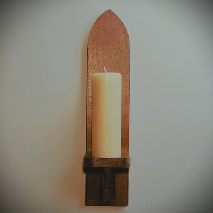 meditation candle on tall wooden wall sconce with grey background