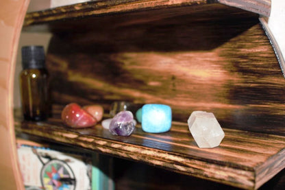 moon wall shelf side view, showing crystals, empty bottle and tarot cards.