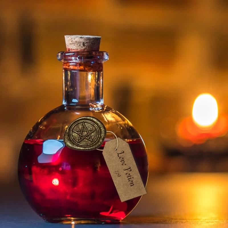 gold wax seal of a pentacle on a corked round bottle containing a red love potion