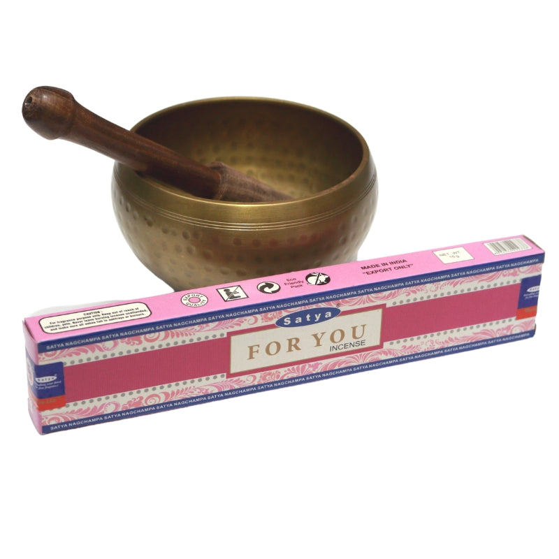 pink box- satya brand "for you" incense in front of brass singing bowl with wooden striker