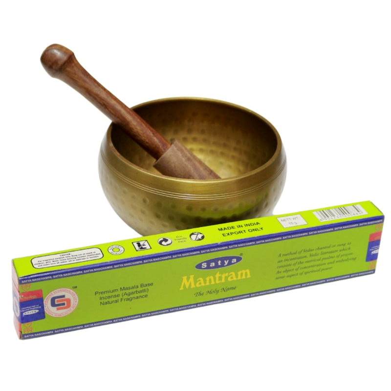 green box- satya brand "mantram" incense in front of brass singing bowl with wooden striker