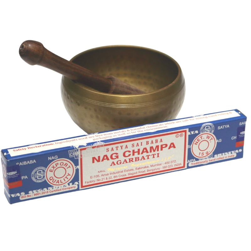 blue box- satya brand "nag champa" incense in front of brass singing bowl with wooden striker