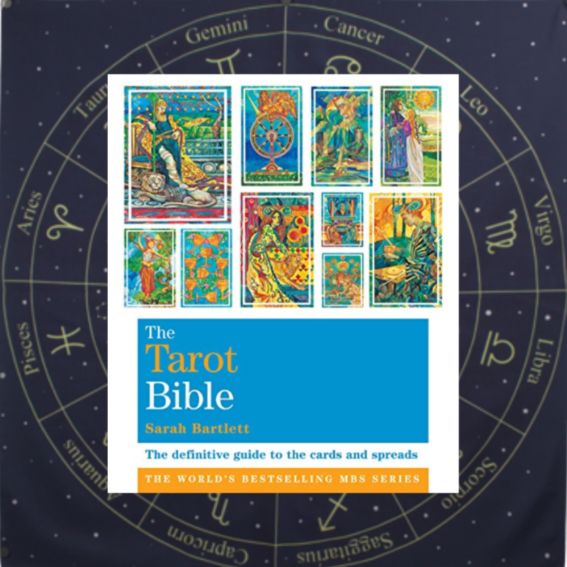 The Tarot Bible on top of a blue tarot cloth with yellow star sign symbols printed on it