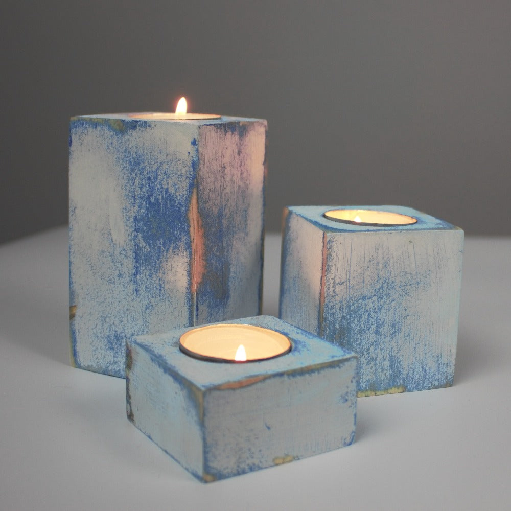 blue and white distressed set of 3 candle holders with lit tea light candles